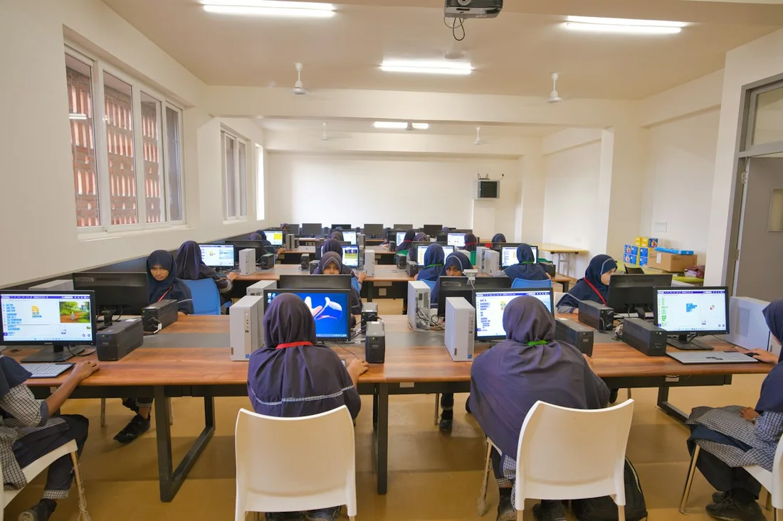 Rows of computers sit empty in a quiet, unused lab.